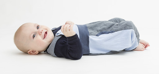 Image showing smiling toddler laying on his back