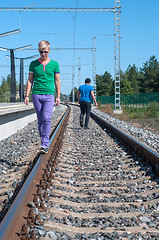 Image showing Handsome man walking on train tracks
