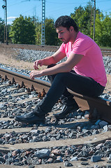 Image showing One man in pink on train tracks
