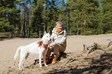 Image showing The woman with a white dog in a wood