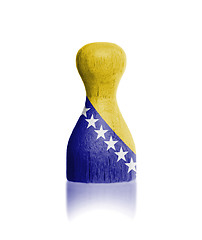 Image showing Wooden pawn with a painting of a flag