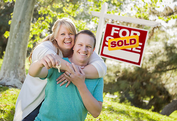 Image showing Couple In Front of Sold Real Estate Sign Holding Keys