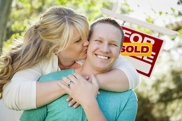 Image showing Happy Couple In Front Sold Real Estate Sign