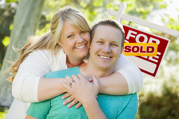 Image showing Happy Couple In Front Sold Real Estate Sign