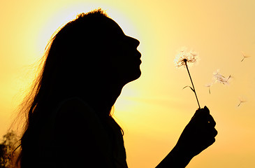 Image showing silhouette of girl blowing to dandelion