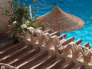 Image showing Beach umbrella, straw circular, against water surface