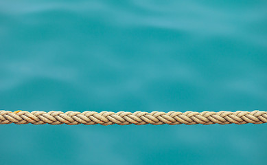 Image showing Thick ship rope on the sea water background