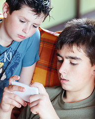 Image showing Teenager boys playing on smartphone, outdoor