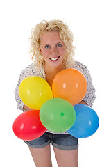 Image showing Young woman holding balloons