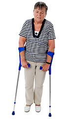 Image showing Old woman walking on crutches