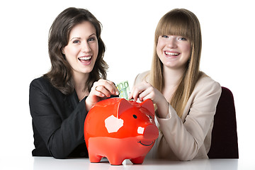 Image showing Two women with piggy bank