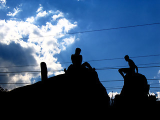 Image showing shapes of two people seated on a rock in the sky