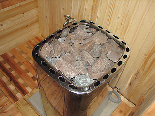 Image showing classic wooden dry sauna inside hot stones to make steam