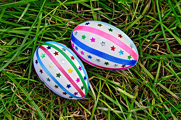 Image showing Easter eggs with ribbons and sequins on grass