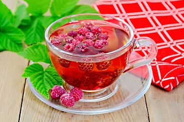 Image showing Tea with raspberry and a napkin on board