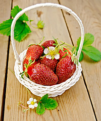 Image showing Strawberries in basket with flowers on board