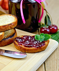 Image showing Bread with cherry jam on a board