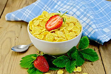 Image showing Cornflakes in white bowl with strawberries on board