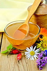 Image showing Honey with flowers and spoon on board