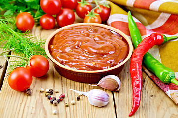 Image showing Ketchup in pottery with vegetables on board