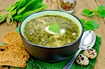 Image showing Soup green sorrel and nettles with a spoon on board