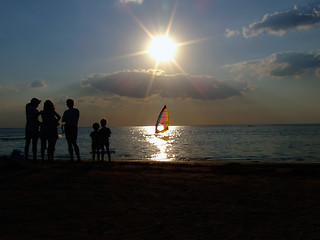 Image showing Silhouette of people looking at windsurf at sunset