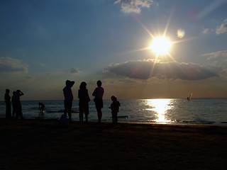 Image showing Silhouette of people looking at windsurf at sunset 2