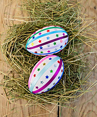 Image showing Easter eggs with ribbons and sequins on board