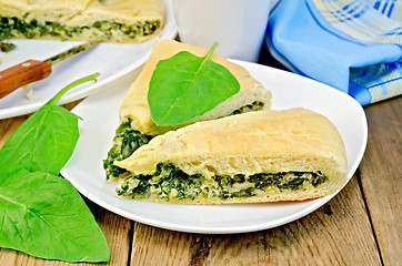 Image showing Pie spinach and cheese with leaves and knife