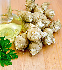 Image showing Jerusalem artichokes with oil and parsley on board