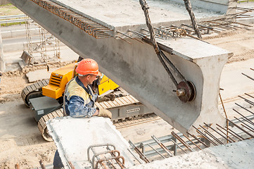 Image showing Workers mount bridge span