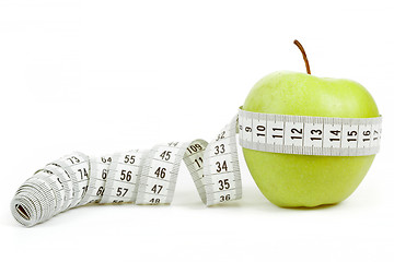 Image showing green apple with a measuring tape and heart symbol isolated