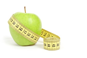 Image showing green apple with a measuring tape and heart symbol isolated