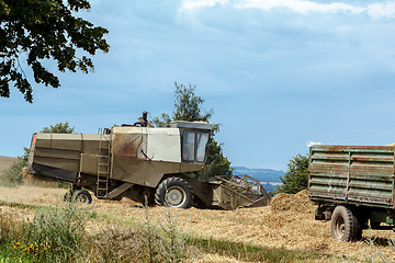 Image showing old combine on field harvesting gold wheat