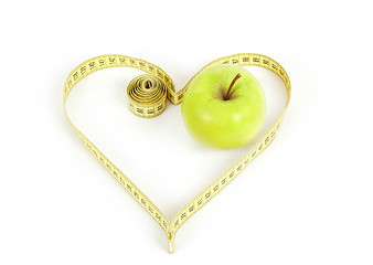 Image showing green apple with a measuring tape and heart symbol isolated