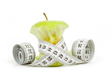 Image showing Green bitten apple isolated on white with measuring tape