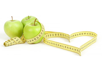 Image showing green apple with a measuring tape and heart symbol isolated