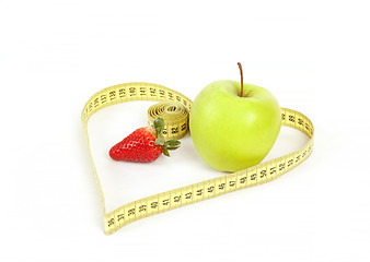 Image showing green apple with a measuring tape and heart symbol isolated