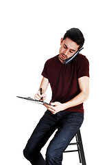 Image showing Man on phone and writing.