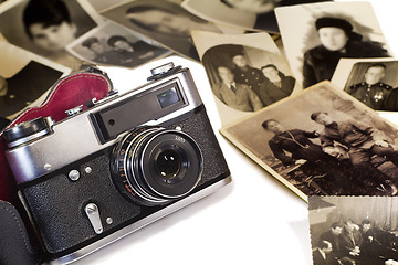 Image showing The old film camera and ancient photos on a white background.