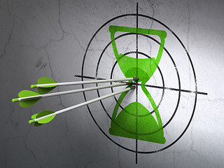 Image showing Time concept: arrows in Hourglass target on wall background