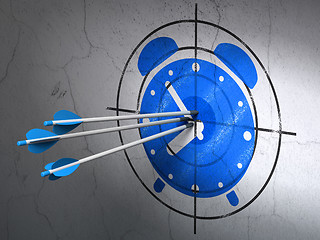 Image showing Time concept: arrows in Alarm Clock target on wall background