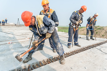 Image showing Workers mount bridge span