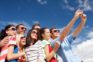 Image showing group of friends taking picture with smartphone