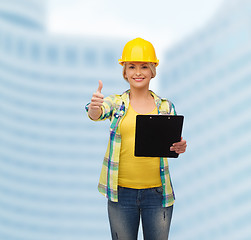 Image showing smiling woman in helmet with clipboard