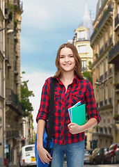 Image showing smiling female student with bag and notebooks