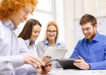 Image showing smiling team with table pc and papers working