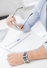 Image showing businessman with spectacles writing in notebook