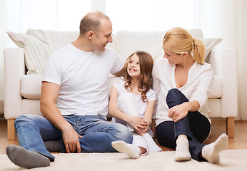 Image showing parents and little girl sitting on floor at home