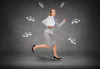 Image showing stressed young businesswoman with clock running